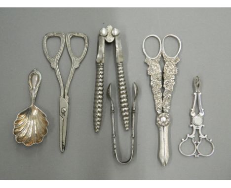 A quantity of various tongs, a caddy spoon, etc., including silver. Largest tongs 16.5 cm long.
