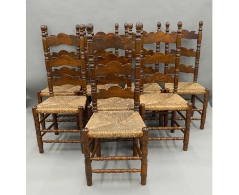 Eight ladder back rush seated chairs. 118 cm high.