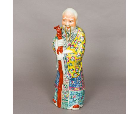 A late 19th/early 20th century Chinese porcelain figure of a sage, modelled wearing colourful robes holding a staff, and with