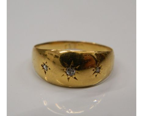 A small 18 ct gold three stone diamond gypsy set ring. Ring size H/I (1.5 grammes total weight).