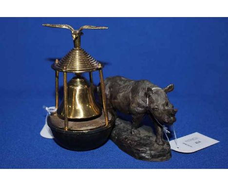 RESIN SCULPTURE OF A RHINO AFTER MARK CORETHsigned to base, 17cm long; together with a brass bell with eagle finial (2)
