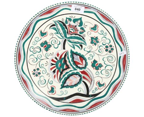 A Poole Pottery charger, with stylised floral design, signed S Russell, 34cm 