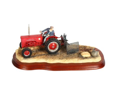 A Border Fine Arts sculpture of a tractor driver, on wooden plinth, "lifting the pinks - international B250 tractor", no. 663