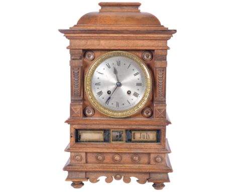 An unusual walnut-cased calendar mantel clock, with silvered dial and 8-day gong striking movement, with calendar mechanism b