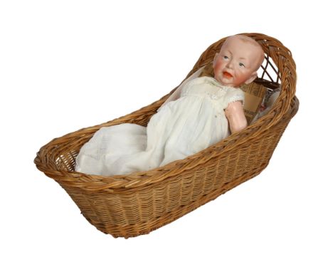 Antique Kammer & Reinhardt porcelain-headed baby boy doll, with jointed composition limbs, 35cm, with wicker crib 