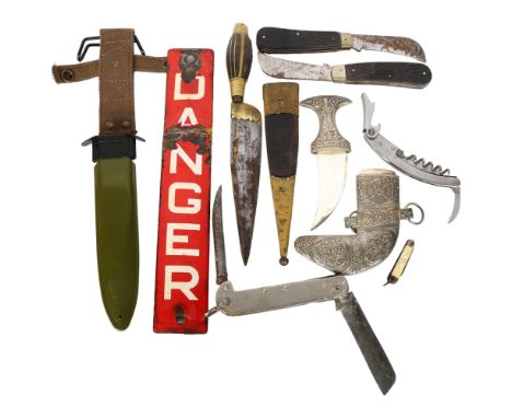 A group of various knives, including a small decorative Jambiya, a brass-bound Middle Eastern knife, a clasp knife, a red ena