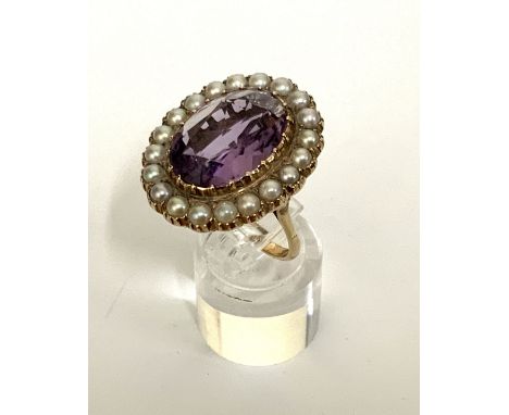 A 9ct gold dress ring inset with a large amethyst surrounded by seed pearls. (A)