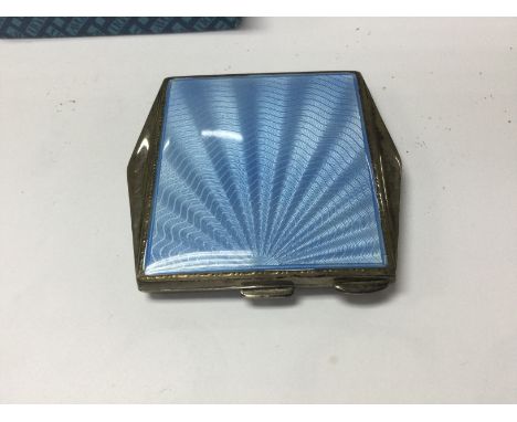 A silver and enamel compact .