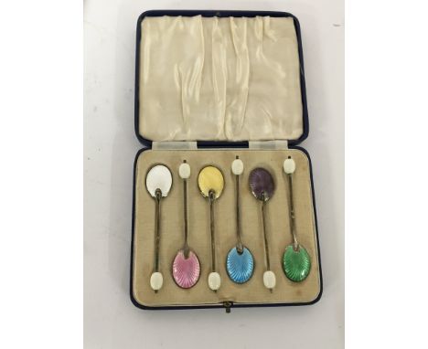 A cased set of silver and enamel coffee spoons.