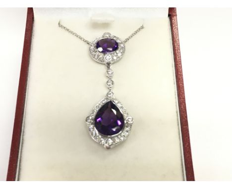 18ct white gold pendant set with a pear shaped amethyst an oval amethyst and RBC diamonds. Amethyst 4.23ct and diamonds 0.66c