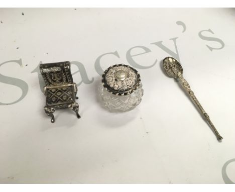 A small collection of silver including a miniature chair a spoon and a jar.