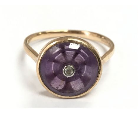 A 9 carat gold Amethyst with a single diamond stone ring, size S. 3.5g total weight. postage category A