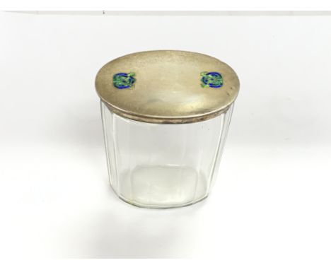 A Liberty and co Archibald knox silver lidded glass dressing table jar with celtic enamel circa 1915. Good condition but very