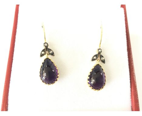 A pair of 9ct yellow gold and silver drop earrings set with oval cabochon amethyst with rose cut diamond set bales. Amethyst 