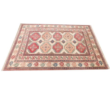 A Kazak style Persian carpet, with a design of medallions, on a cream ground, 342cm x 223cm. 