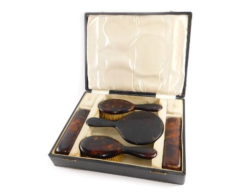 An imitation tortoiseshell dressing table set, in fitted case, comprising four brushes and hand mirror.&nbsp;