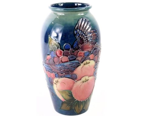 A William Moorcroft ovoid vase, on a blue ground, decorated with finches, fruits and berries, signed and stamped to underside