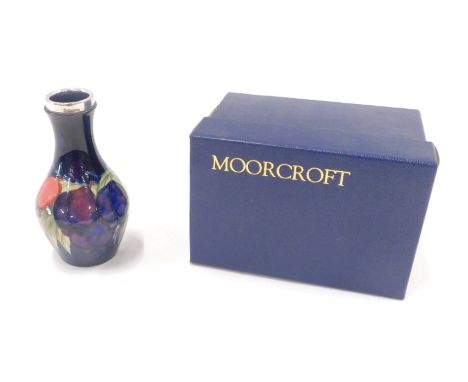 A Moorcroft vase, with a silver plated collar on a blue fruit blossom pattern, numbered 372, 15cm high, boxed. 