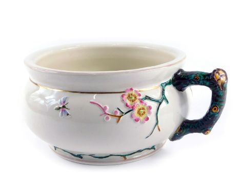 A late 19thC Minton style chamber pot, on a cream ground, with raised relief decoration of flowers and butterflies, with tree
