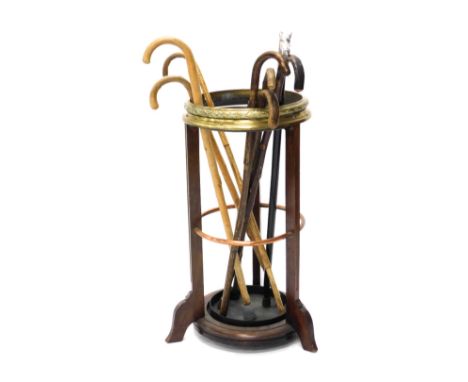 An early 20thC mahogany brass and copper banded umbrella stand, or stick stand, and various walking sticks. 