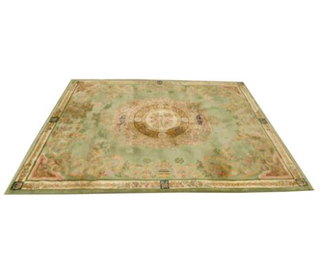 A Chinese full cut pile carpet, with all over multicoloured design, on a green ground, 437cm x 321cm, sold with original rece