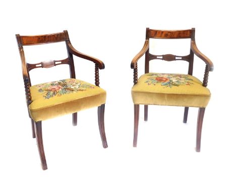A pair of Regency mahogany open armchairs, each with a bar back, moulded arms, on bobbin turned supports, with floral upholst