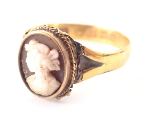 A 22ct gold cameo dress ring, a central raised and carved cameo depicting a maiden looking dexter, with a rope twist border o