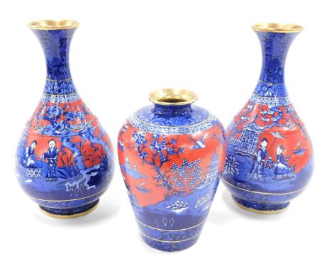 A pair of Foley ware Oriental style vases, each on a blue and red ground, 30cm high, and a similar vase 20cm high. (3, AF)