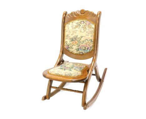 An early 20thC stained beech folding rocking chair with tapestry upholstery. 