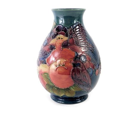 A William Moorcroft vase, on a blue ground, decorated with finches, fruits and berries, signed and stamped to underside, 20cm