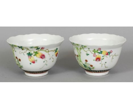 A PAIR OF CHINESE FAMILLE ROSE PORCELAIN BOWLS, each decorated with bamboo, rockwork and hanging fruit, each base with a Daog