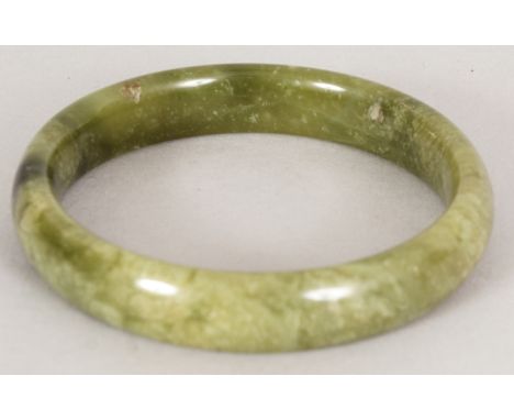 A CHINESE PALE SPINACH GREEN JADE BANGLE, 2.8in diameter, the inner rim 2.25in diameter.