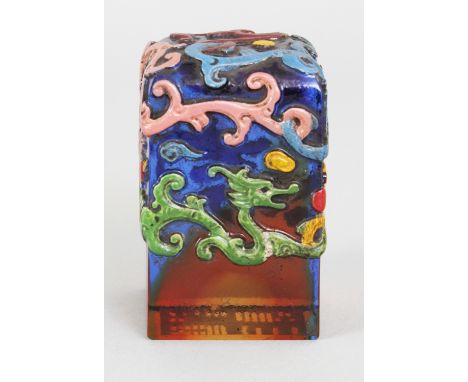 A CHINESE ENAMELLED GLASS SEAL, the sides and top surface decorated in relief with sinuous dragons, 1.7in square & 2.8in high