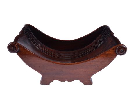 A George III mahogany cheese coaster, circa 1810, of curved form, the ends with roundels at each side, raised on bracket feet