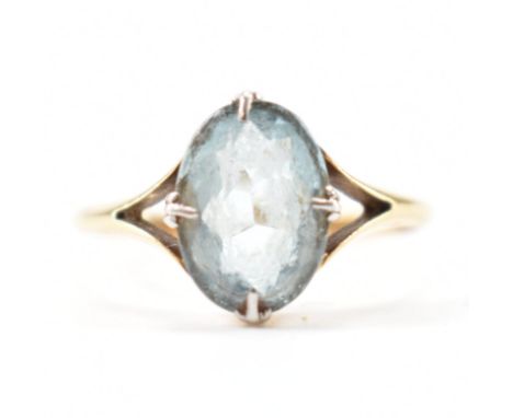 An 18ct gold and aquamarine single stone ring. The ring with an oval cut aquamarine in a white claw setting, mounted in yello