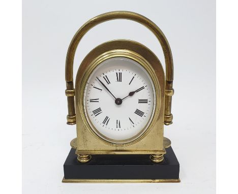 A mantel clock, with oval enamel dial, with Roman numerals, in brass case, 15 cm high 