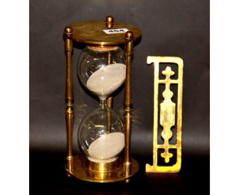 A brass egg timer and a Victorian miniature brass fender, H. 25cm.
