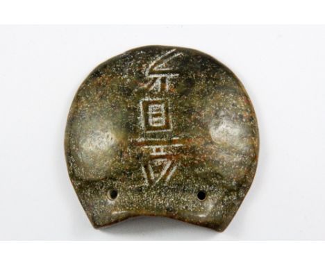 A Chinese carved archaic form olive green and russet protective amulet in the form of a turtle shell, H. 8cm.
