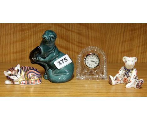 Two small crown Derby paperweights, a Waterford crystal clock and a Poole pottery seal.