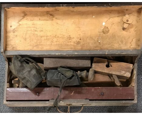 A pine tool chest with a quantity of planes and other tools and two gas masks.