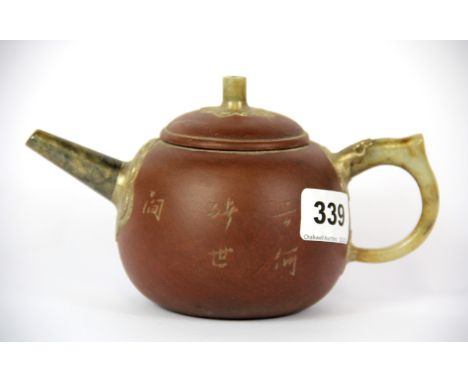 A Chinese Yixing terracotta teapot with jade spout and handle, spout to handle L. 18cm H. 10cm.