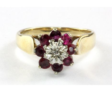 A 9ct yellow gold ruby and diamond set cluster ring, (L.5).