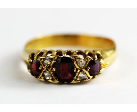 An 18ct yellow gold (worn hallmark) ruby and diamond set ring, (P).