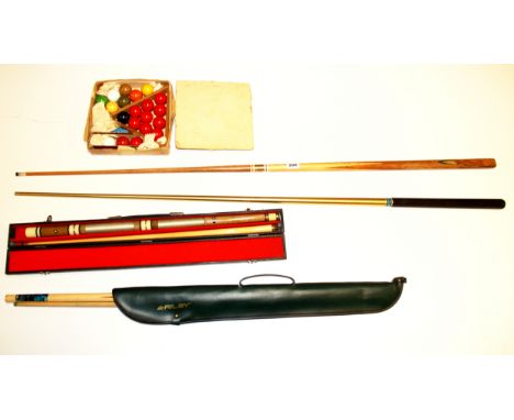 A set of vintage snooker balls and three cues.