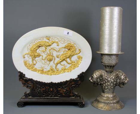 An oriental gilt decorated plate on a carved wooden stand together with a white metal lion head candlestick, plate W. 36cm Ca