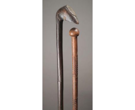 A Zulu club South Africa wood with a bird head having an oval flat front, 90cm long, and a Zulu staff, with a spherical finia