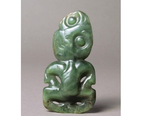 A Maori hei-tiki pendant New Zealand nephrite, the tilted head with an attachment hole to the top and with hands on the thigh