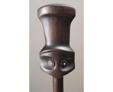 A Vanuatu club Polynesia wood with shell inlay, having a stylised Janus head finial and an ovoid knop terminal, 77cm long.