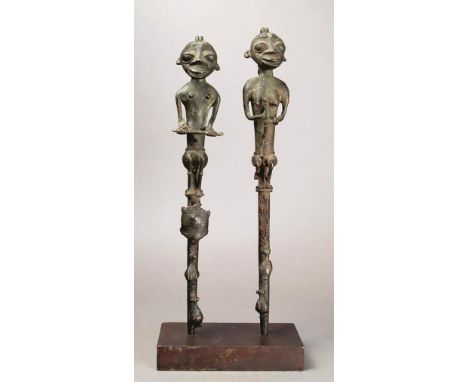 A pair of Yoruba Edan staffs Nigeria brass, with a male and female figure, holding rods and with birds below, the male with a