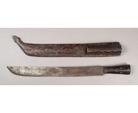 A Paiwan ceremonial sword and scabbard Taiwan with a steel blade with initials I.C, with a wooden handle carved a figure eith